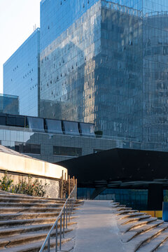 Reflections on glass building facade with geometric patterns and steps in foreground, modern architecture and design concepts for business and design stock.