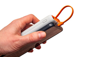 A hand holds a power bank, shown with a smartphone, against a bright white backdrop for easy...