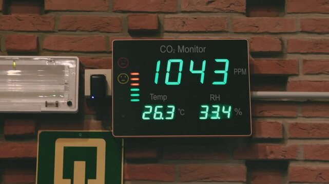 CO2 monitor displays air quality data in crowded hall with high attendance during event