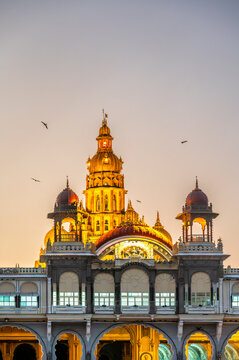 Mysore Palace in Karnataka, India, at sunset with birds in the sky