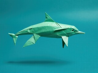  An exquisite origami dolphin calf gracefully unfolds against a tranquil teal backdrop