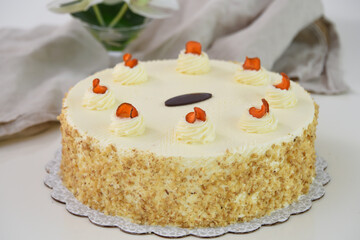 Elegant Carrot Cake with Cream Cheese Frosting and Drizzle spiced cake layers covered in smooth cream cheese frosting top is elegantly drizzled with caramel with napkin side view of delicious cake