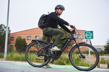 Obraz premium Man riding electric bike in city bicycle lane