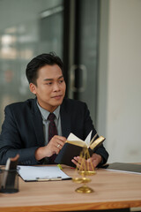 lawyer sits reading a book studying the law in a law office.