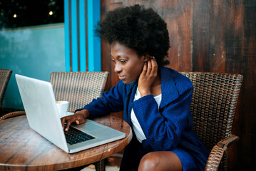 Businesswoman working on laptop at outdoor cafe
