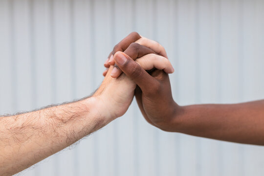 Woman and man holding hands by wall