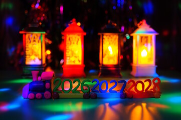 A toy train made of plasticine with the numbers 2026, 2027 and 2028 on the background of glowing lanterns. A festive event.