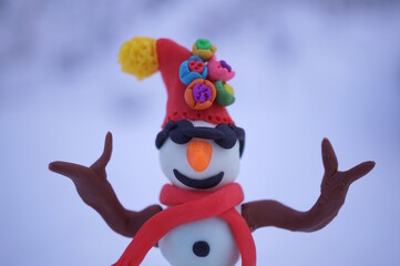 A snowman wearing plasticine glasses on a snow background.