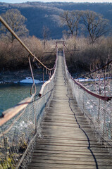Obraz premium A mountain suspension bridge over the river