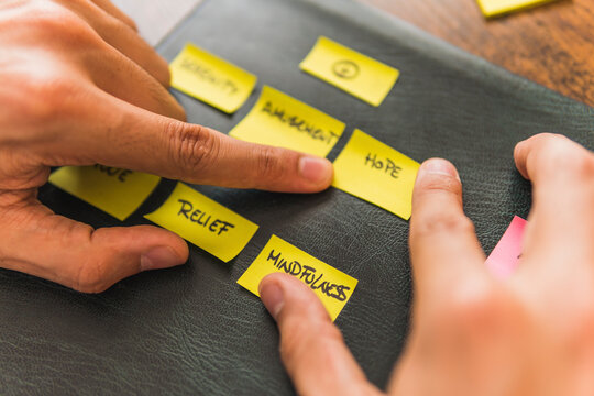 Male psychologist with yellow adhesive notes on black leather at office