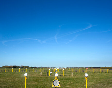 Runway at Leeuwarden airforce base with contrails from a NATO exercise in the sky