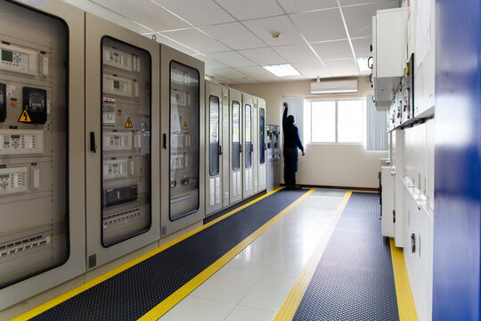 Engineer in a substation control room monitoring electrical systems