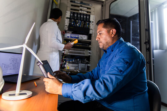 Engineers monitoring electrical systems in a substation with renewable energy equipment