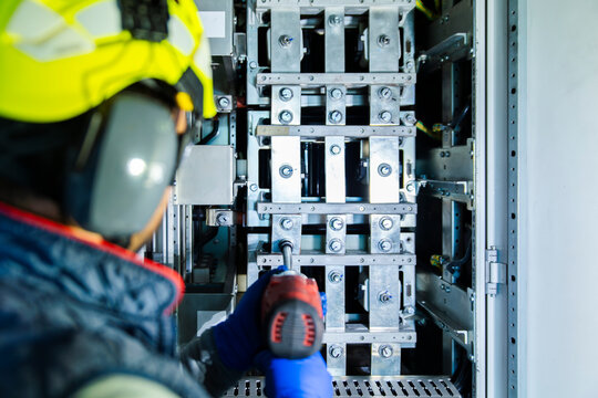 Engineer performing maintenance on a medium voltage cell in a wind turbine tower