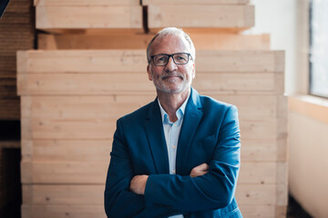Confident engineer in a suit smiling indoors with wooden background