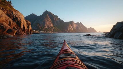 Scenic view from a kayak in calm waters, surrounded by majestic mountains at sunset, ideal for adventure travel