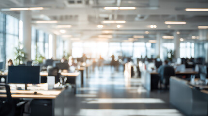 Obraz premium Bright and spacious open-plan office interior with desks, monitors, and natural light flooding through large windows, creating a productive atmosphere.