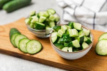 Cucumber on wooden background. Slice of cucumber on background. Fresh organic green cucumbers gherkin. Vegan. Salad ingredient. Farm vegetables. Cut vegetables with knife. Space for text. Copy space