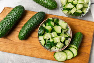 Cucumber on wooden background. Slice of cucumber on background. Fresh organic green cucumbers gherkin. Vegan. Salad ingredient. Farm vegetables. Cut vegetables with knife. Space for text. Copy space