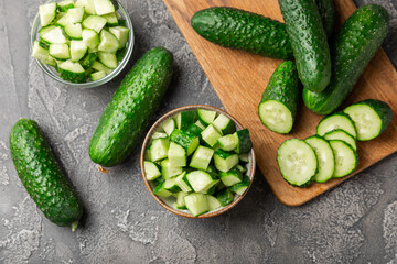 Cucumber on wooden background. Slice of cucumber on background. Fresh organic green cucumbers gherkin. Vegan. Salad ingredient. Farm vegetables. Cut vegetables with knife. Space for text. Copy space