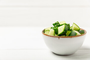 Cucumber on wooden background. Slice of cucumber on background. Fresh organic green cucumbers gherkin. Vegan. Salad ingredient. Farm vegetables. Cut vegetables with knife. Space for text. Copy space