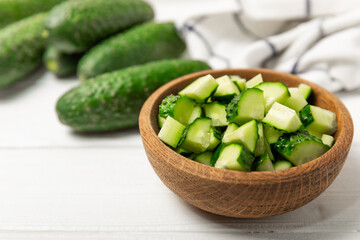 Cucumber on wooden background. Slice of cucumber on background. Fresh organic green cucumbers gherkin. Vegan. Salad ingredient. Farm vegetables. Cut vegetables with knife. Space for text. Copy space