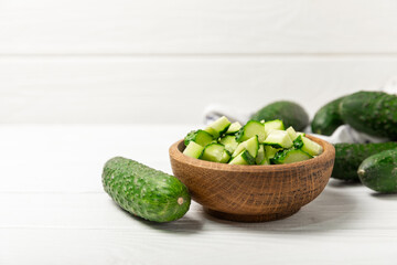 Cucumber on wooden background. Slice of cucumber on background. Fresh organic green cucumbers gherkin. Vegan. Salad ingredient. Farm vegetables. Cut vegetables with knife. Space for text. Copy space