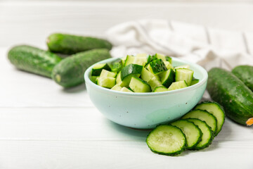 Cucumber on wooden background. Slice of cucumber on background. Fresh organic green cucumbers gherkin. Vegan. Salad ingredient. Farm vegetables. Cut vegetables with knife. Space for text. Copy space