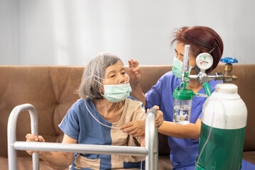 Elderly woman wearing oxygen nasal cannula at home.