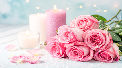 Pink roses bouquet with lit candles and sprinkles on a blurred background.