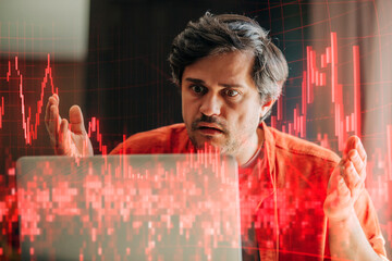 Man in panic watching falling stock quotes on laptop during financial crisis