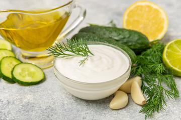 Cucumber sour cream tzatziki sauce on a wooden table.Tartar sauce. Traditional delicious appetizer. yogurt sauce. Tzatziki with ingredients cucumber, garlic,dill,lemon,mint. salad dressing.Copy space