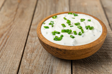 Cucumber sour cream tzatziki sauce on a wooden table.Tartar sauce. Traditional delicious appetizer. yogurt sauce. Tzatziki with ingredients cucumber, garlic,dill,lemon,mint. salad dressing.Copy space