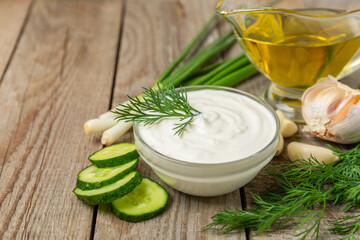 Cucumber sour cream tzatziki sauce on a wooden table.Tartar sauce. Traditional delicious appetizer. yogurt sauce. Tzatziki with ingredients cucumber, garlic,dill,lemon,mint. salad dressing.Copy space