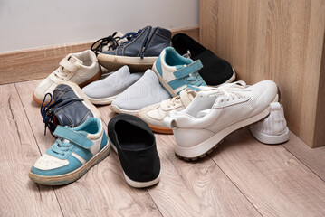 Dirty baby shoes scattered on the floor of the nursery. Decluttering and tidying up