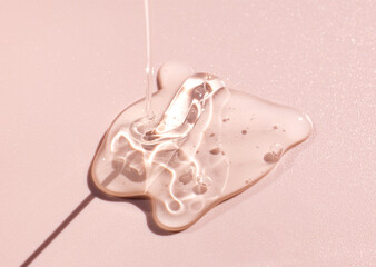 cosmetic sample of transparent gel texture on pink background