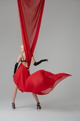 Elegance and daring fusion of beauty and fashion with flowing red fabric