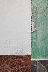 White Wall With Green Peeling Paint. Close-up of Exterior Wall Texture