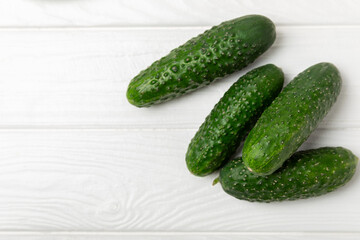 Cucumber on wooden background. Slice of cucumber on background. Fresh organic green cucumbers gherkin. Vegan. Salad ingredient. Farm vegetables. Cut vegetables with knife. Space for text. Copy space
