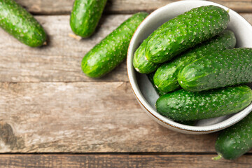 Cucumber on wooden background. Slice of cucumber on background. Fresh organic green cucumbers gherkin. Vegan. Salad ingredient. Farm vegetables. Cut vegetables with knife. Space for text. Copy space