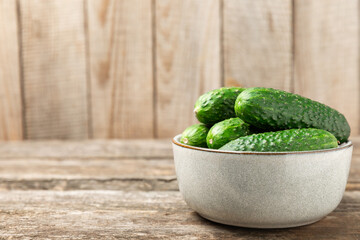 Cucumber on wooden background. Slice of cucumber on background. Fresh organic green cucumbers gherkin. Vegan. Salad ingredient. Farm vegetables. Cut vegetables with knife. Space for text. Copy space