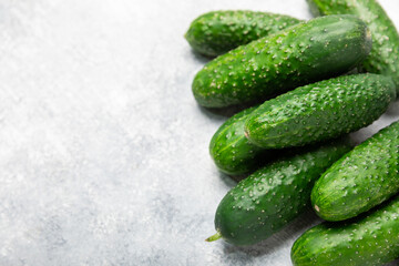 Cucumber on wooden background. Slice of cucumber on background. Fresh organic green cucumbers gherkin. Vegan. Salad ingredient. Farm vegetables. Cut vegetables with knife. Space for text. Copy space