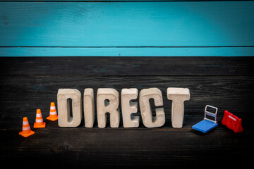 Concrete Word Direct with Traffic Cones and Mini Cart on Dark Wooden Surface