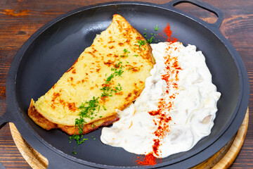 Delicious omelette served with creamy sauce on a frying pan
