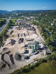 Drone view of construction aggregate plant surrounded by countryside and highway