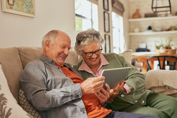 Happy smiling old couple using digital tablet at home