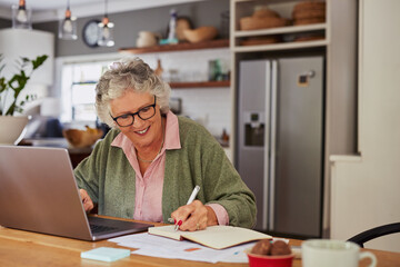 Happy senior woman working at laptop