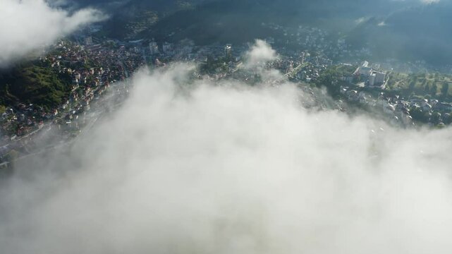 Small city with fog in the mountains drone footage