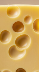 A perfect close up of a block of swiss cheese featuring many holes in its surface.