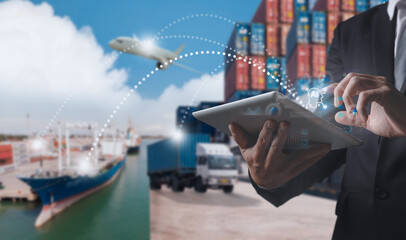 Businessman uses digital tablet with AI interface to manage global logistics including air, sea, and truck freight transportation.
